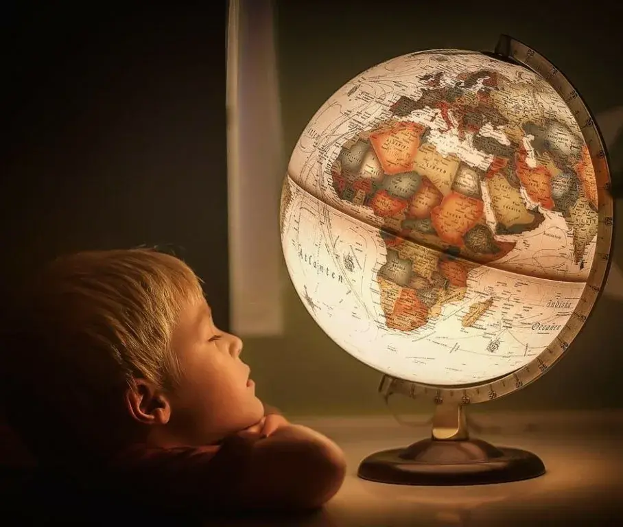 Ребенок и взрослый изучают глобус в день вращения Земли
