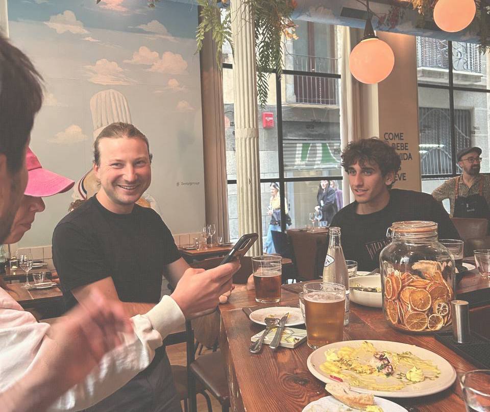 The Tres Gatos team at a table inside Sensi, Barcelona, with the chef mural behind them