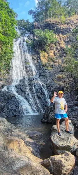 Турист на камне перед водопадом
