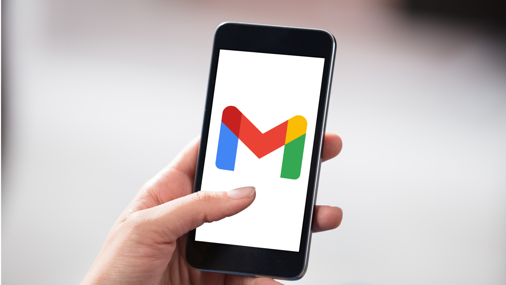 Mão segurnado um smartphone com a logo do gmail