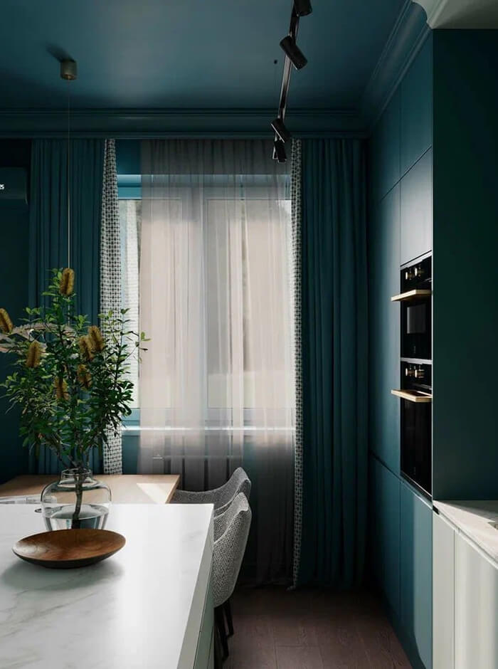 Светлая комната, голубые стены и потолок, встроенная кухонная техника