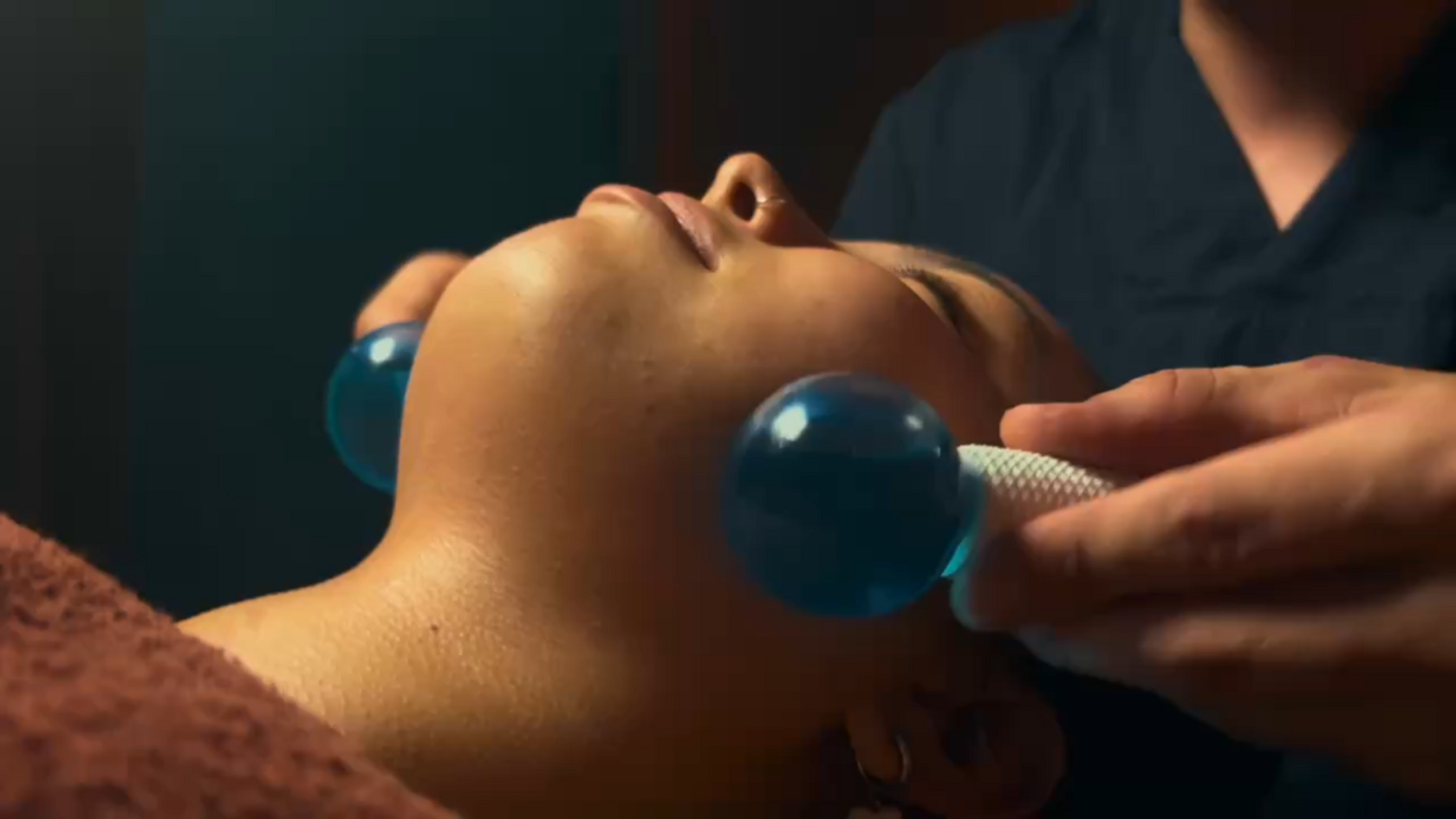 Мастер делает расслабляющий массаж лица криосферами в студии ПАУЗА. Мягкий свет, спокойствие и руки профессионала для Вашего релакса.