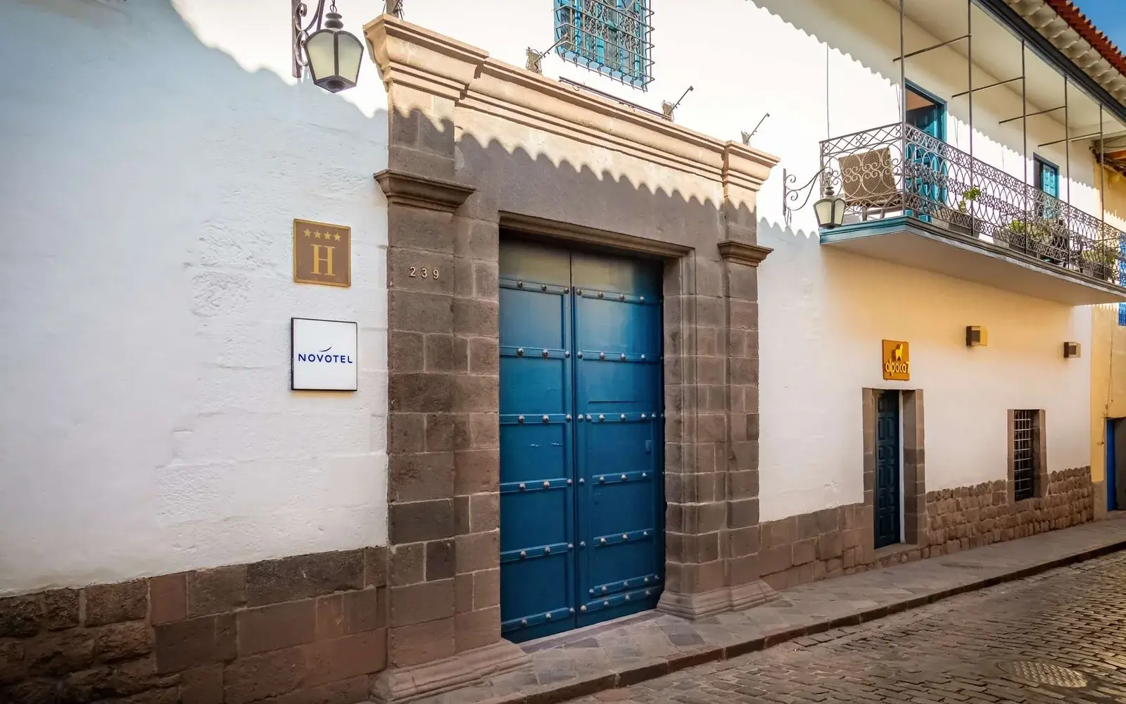 Фасад особняка XVI века с синими воротами на улице Куско, Novotel Cusco