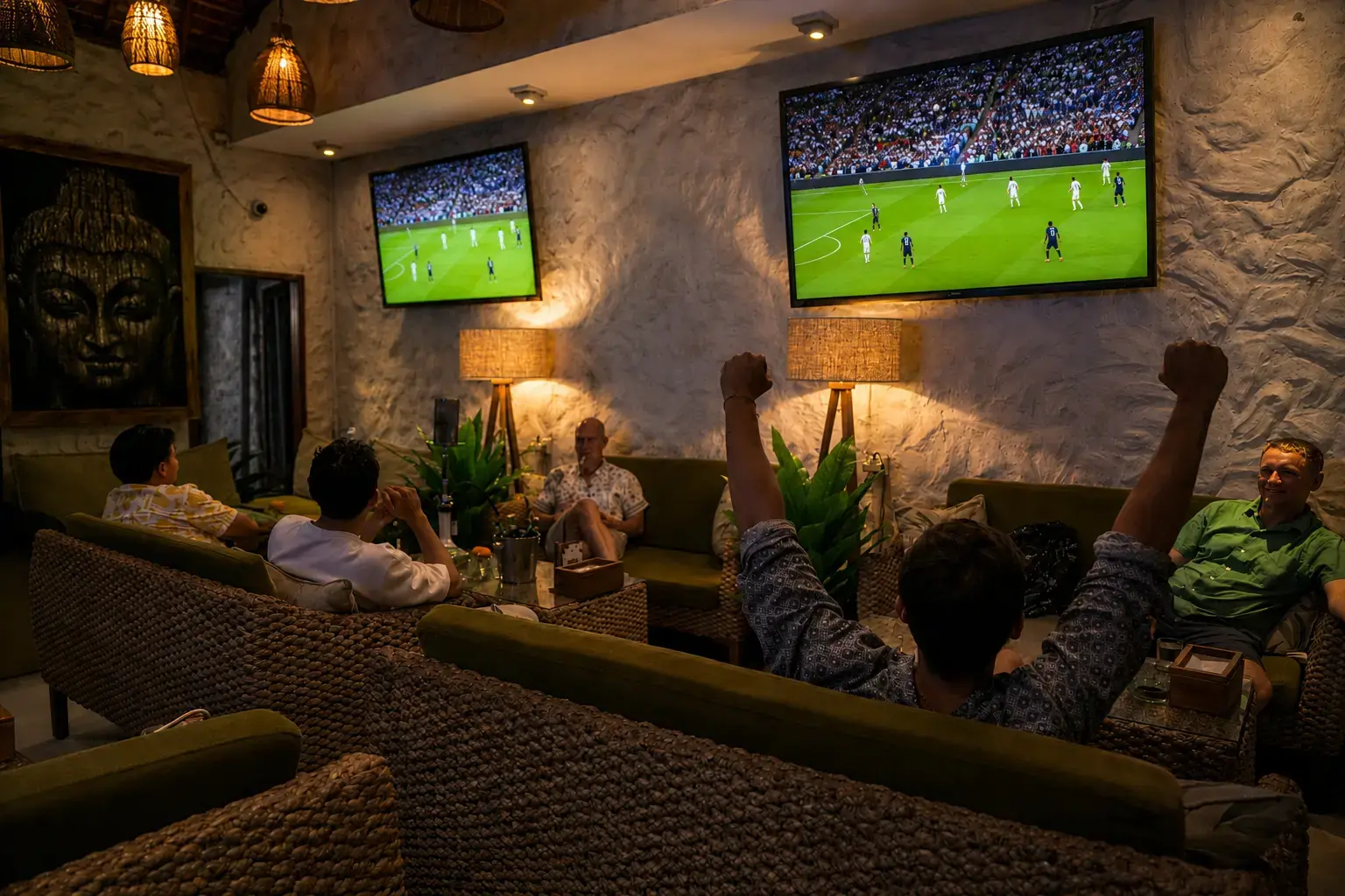 Excited football fans celebrating a live match in front of large screens at a premium sports lounge showcasing the best places to watch FIFA World Cup 2026 in Bali.