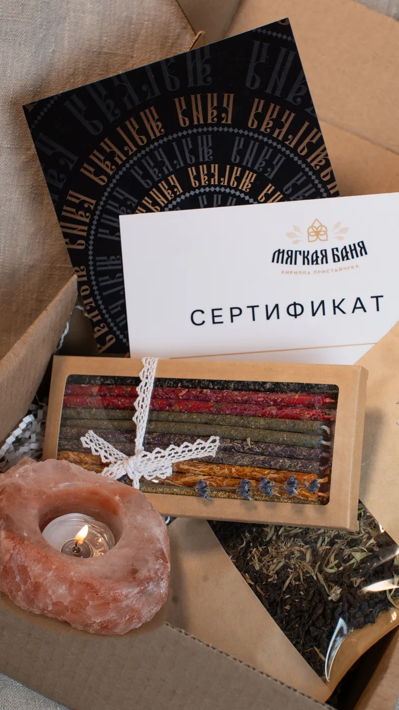 Подарочный сертификат Мягкой бани и зажжённая свеча.