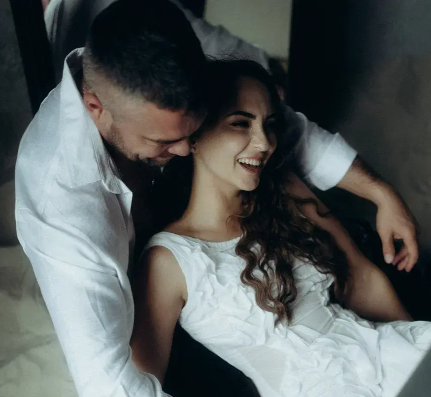 Смеющаяся пара обнимается во время фотосессии Love Story