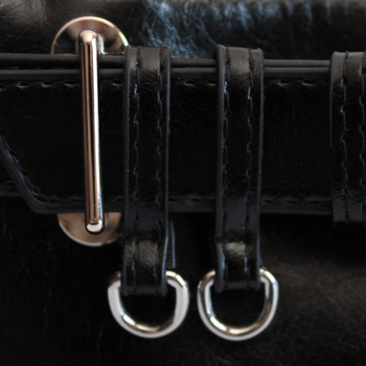 Купить сумку-багет черного цвета с серебристой фурнитурой и ремнем.