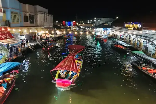 Ночной плавучий рынок с подсвеченными лодками и лавками на воде