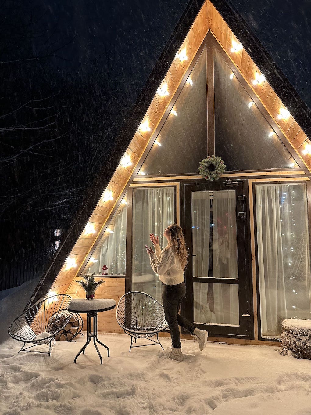 Мини-фотосессия девушки на фоне панорамного окна с зимним пейзажем в афрейм домике.