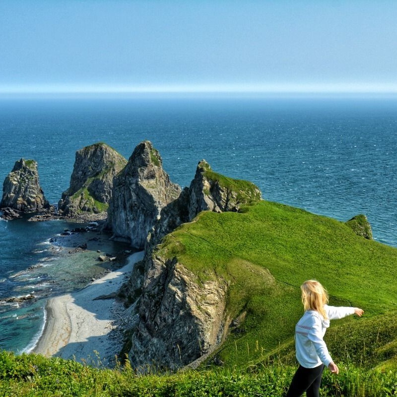 Путешественник на скале с видом на острова