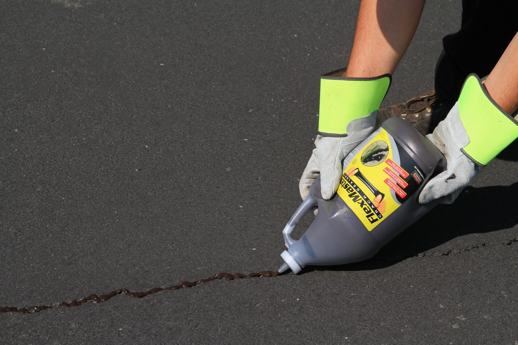 Холоднотвердеющий герметик для трещин FlexMaster наносится на парковке.