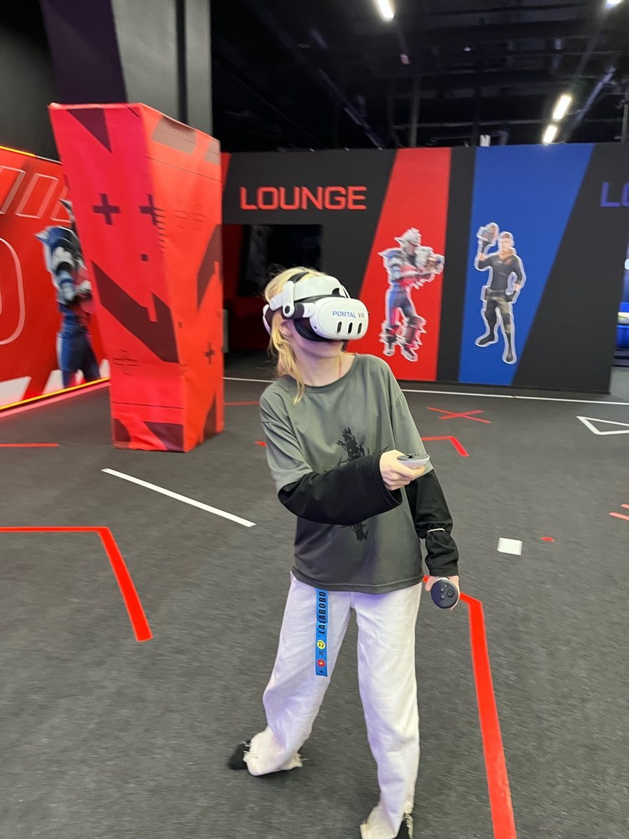 Участник в VR-шлеме с контроллерами на арене Portal VR