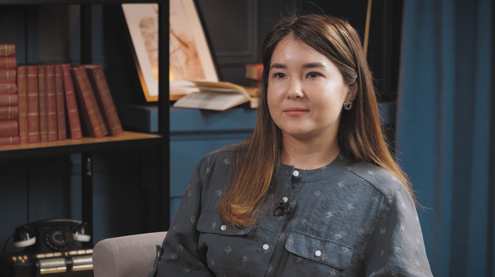 Студия гостья на фоне книжного стеллажа