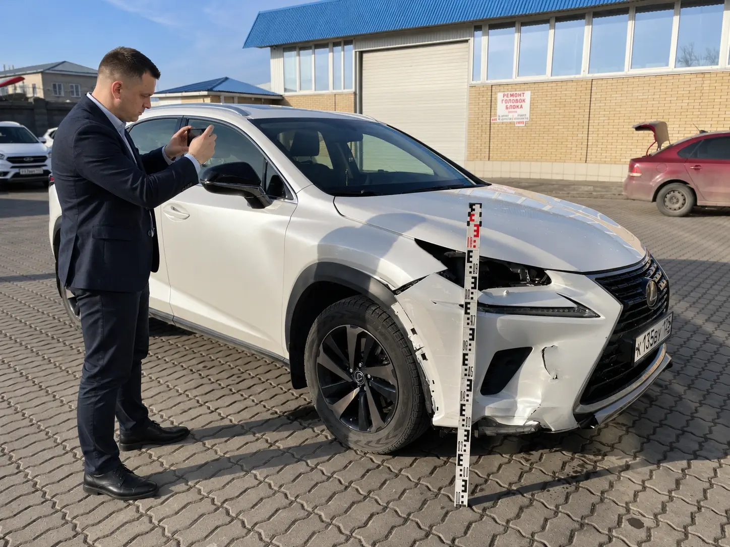 Эксперт фотографирует повреждения Lexus NX после ДТП при оценке ущерба в Минеральных Водах
