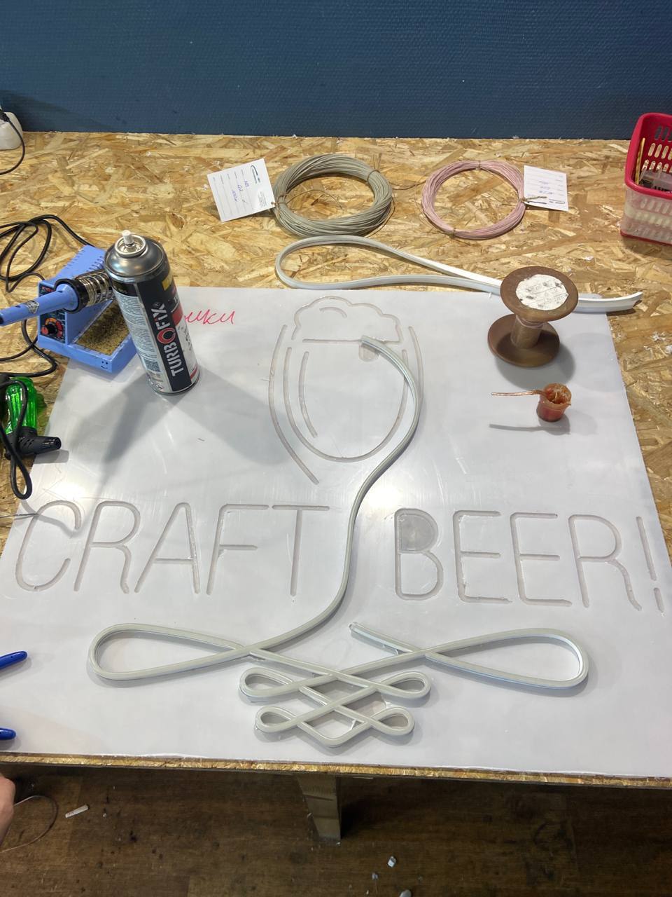 Изготовление неоновой вывески Craft Beer в мастерской NEONES: гибкий неон вклеивают в пазы подложки из оргстекла