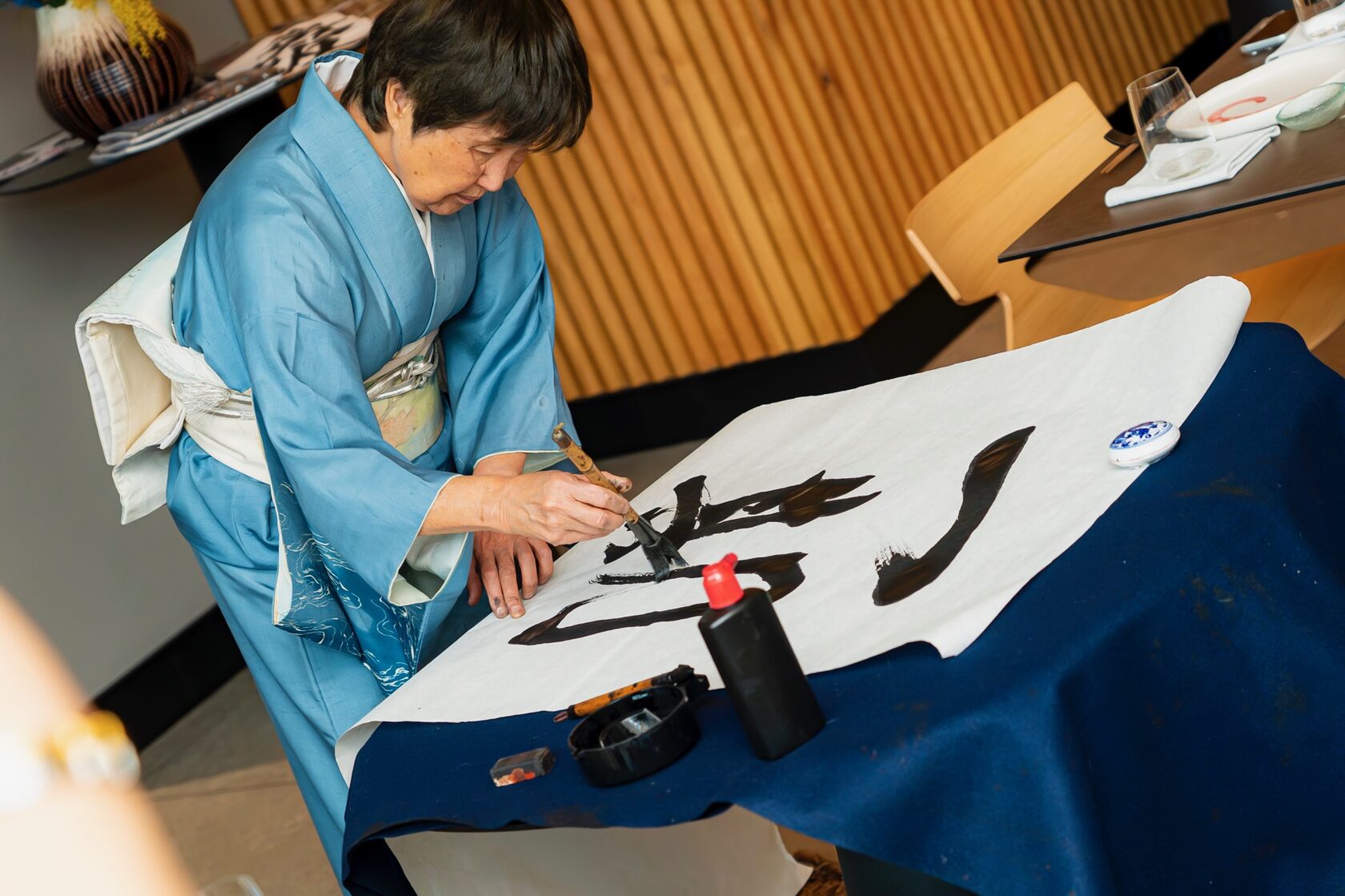 Гост от Япония показва традиционна калиграфия с четка и мастило по време на японския тематичен следобед на дамите от 