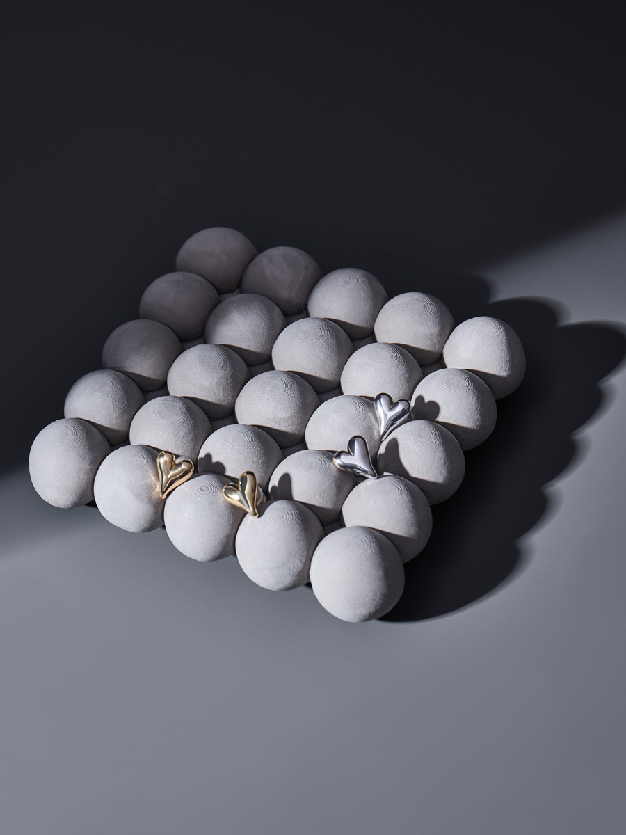 серьги сердечки на камнях на сером фоне тень