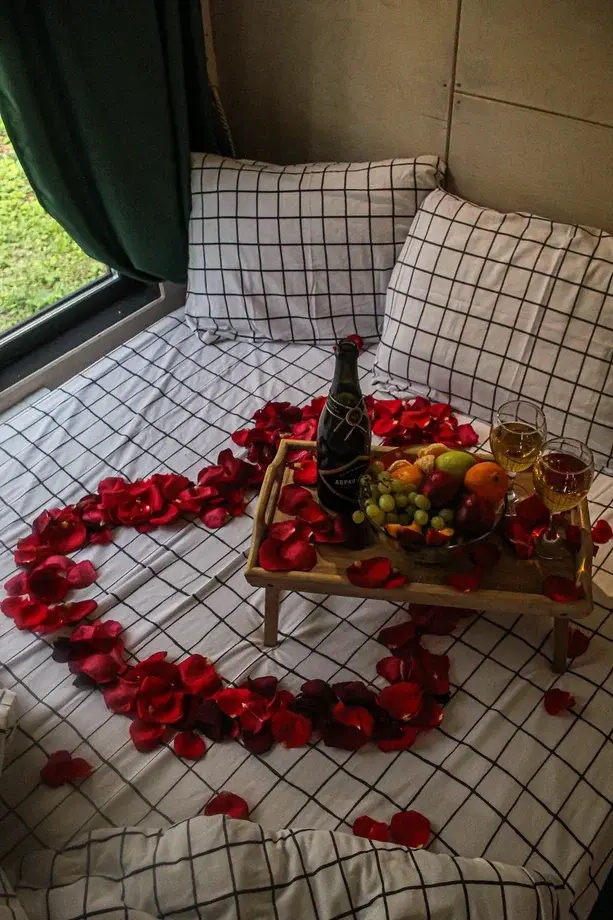Услуга романтического оформления домика в глэмпинге Тишина: сердце из лепестков роз, шампанское и фрукты на кровати с видом на лес — идеально для свидания вдвоём