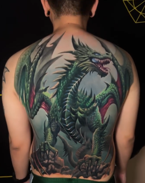 A detailed full-back tattoo of a green fantasy dragon in a dynamic pose, featuring sharp scales, wings, and a fierce expression, executed in a vibrant illustrative realism style, by Rinat Tattarin Mingazdinov