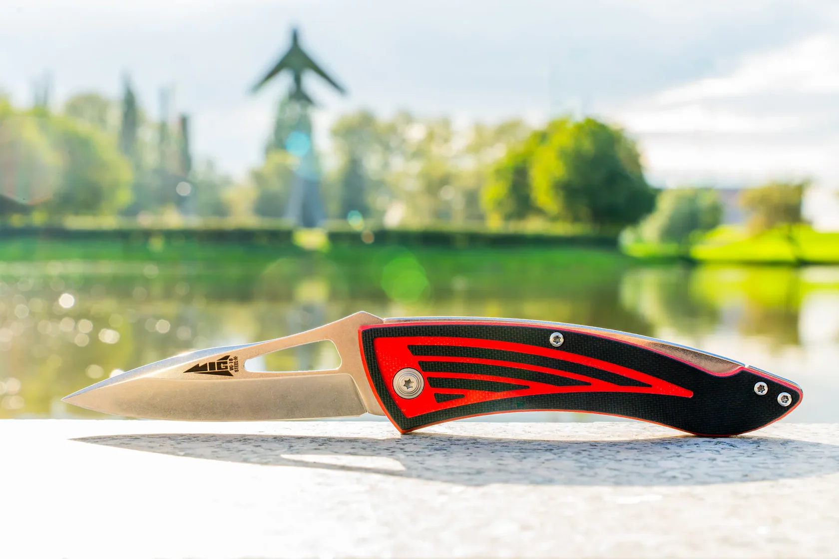 Full profile of the MiG folding knife beside a lake