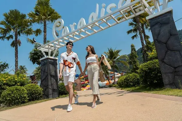 Пара у входной арки курорта Paradise на острове Ко Чанг среди пальм