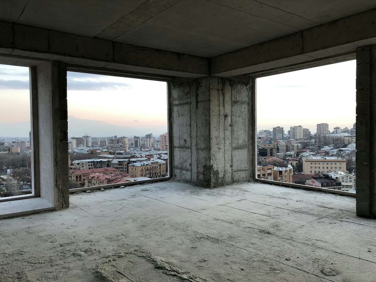 Пустой каркас квартиры с панорамными окнами в новостройке