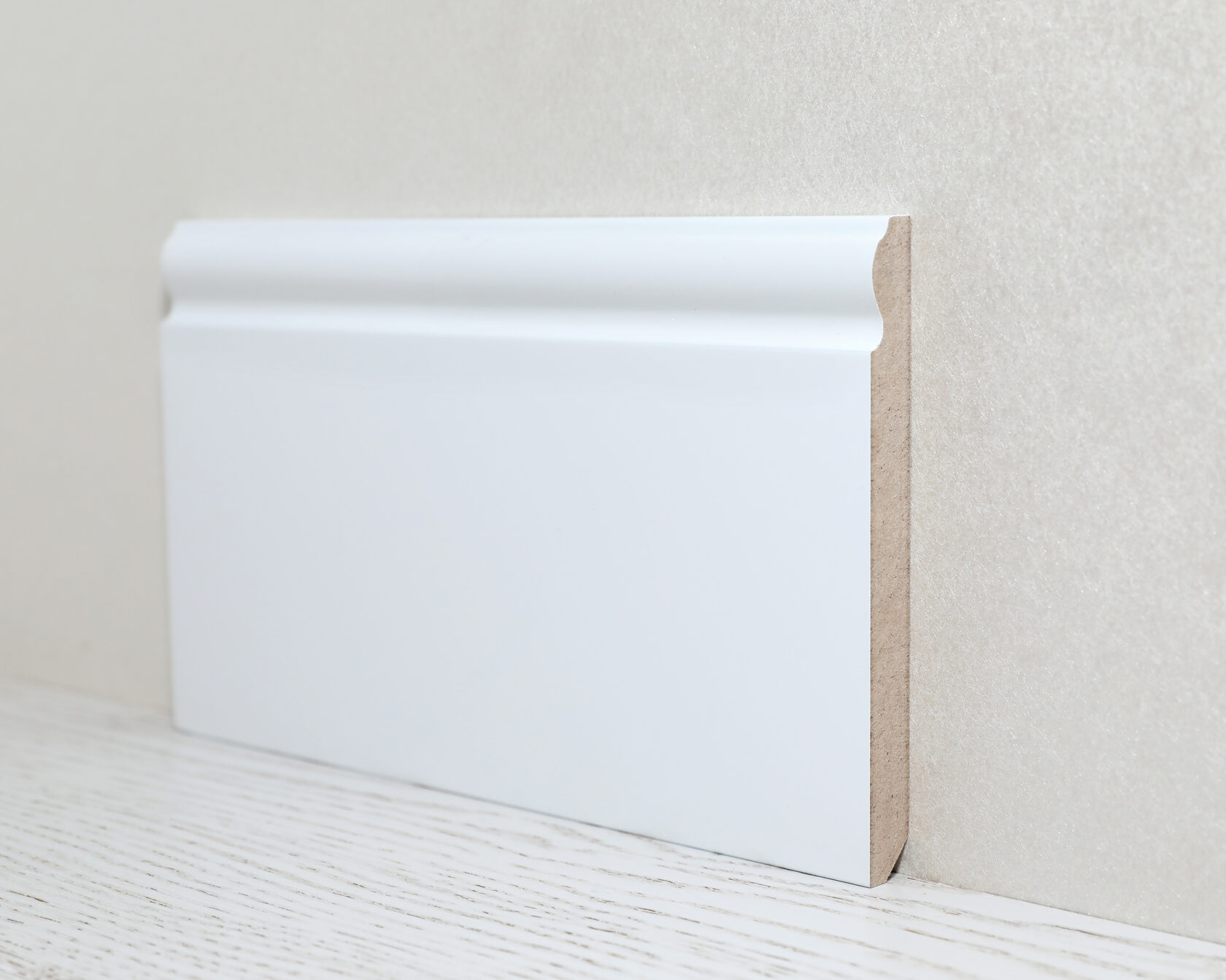 Высокий плинтус из МДФ белого цвета.