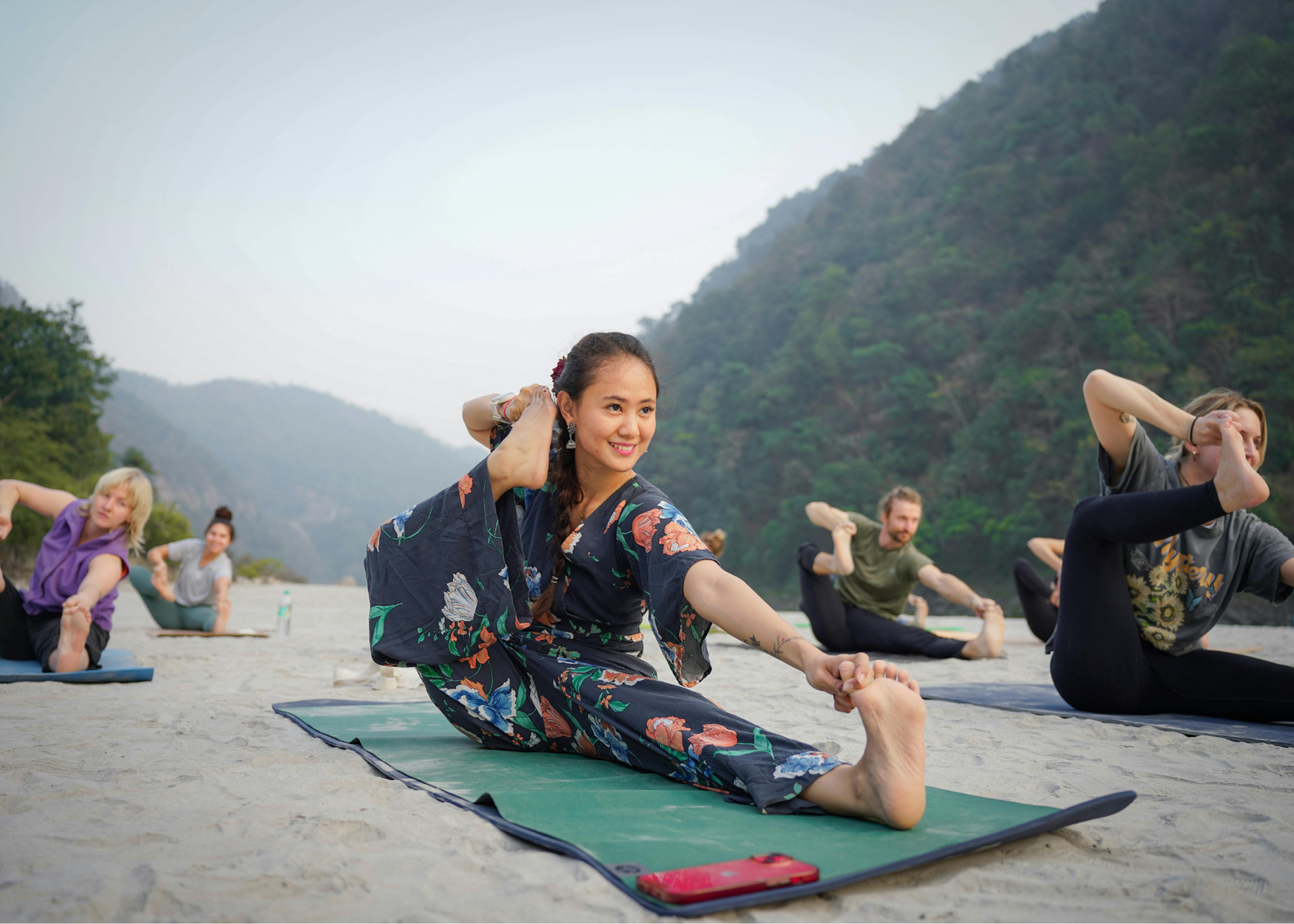 Image: outdoor-yoga-class-b.png Alt text: Outdoor yoga class with students practicing asana in a mountain setting