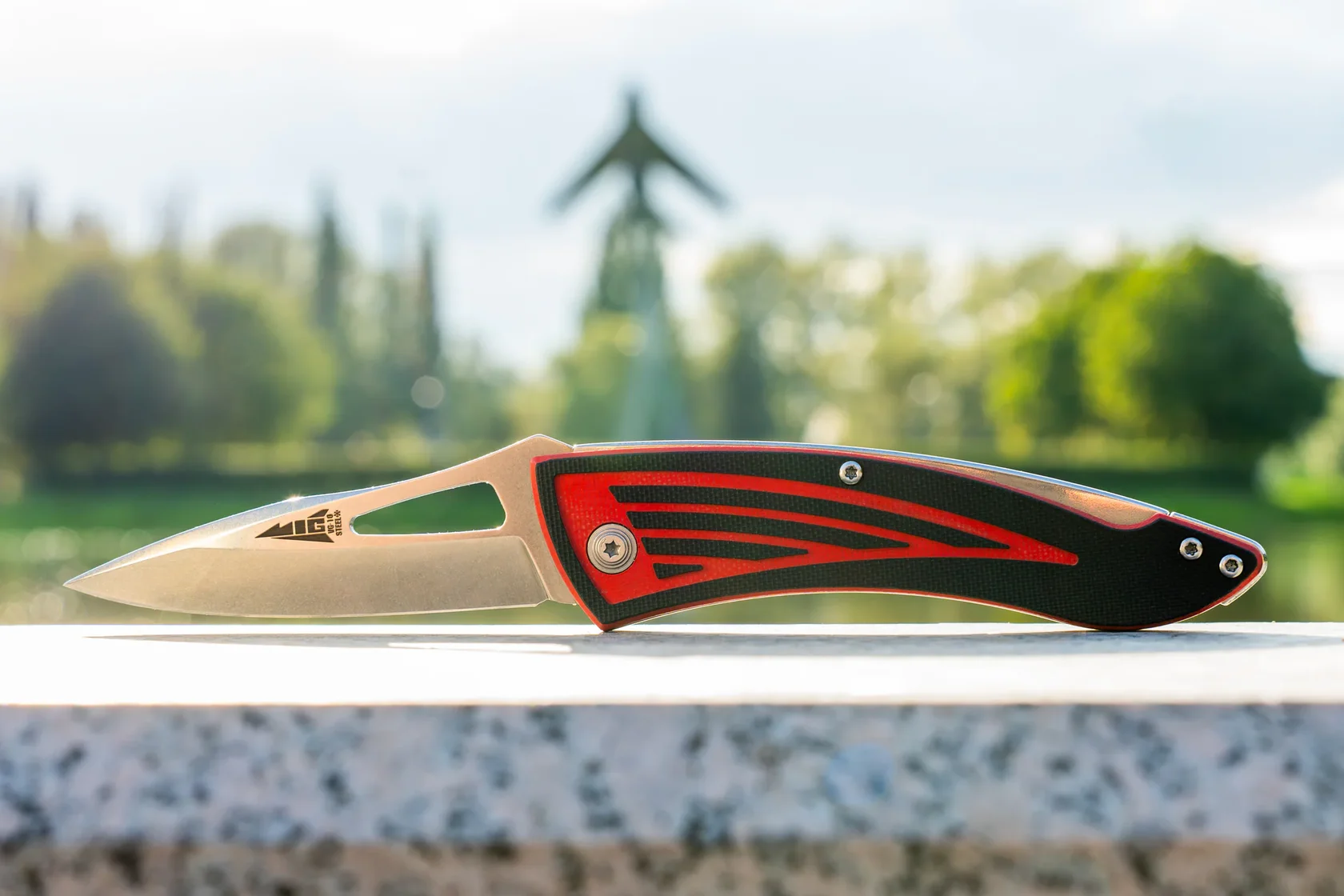 MiG folding knife displayed outdoors by a lake