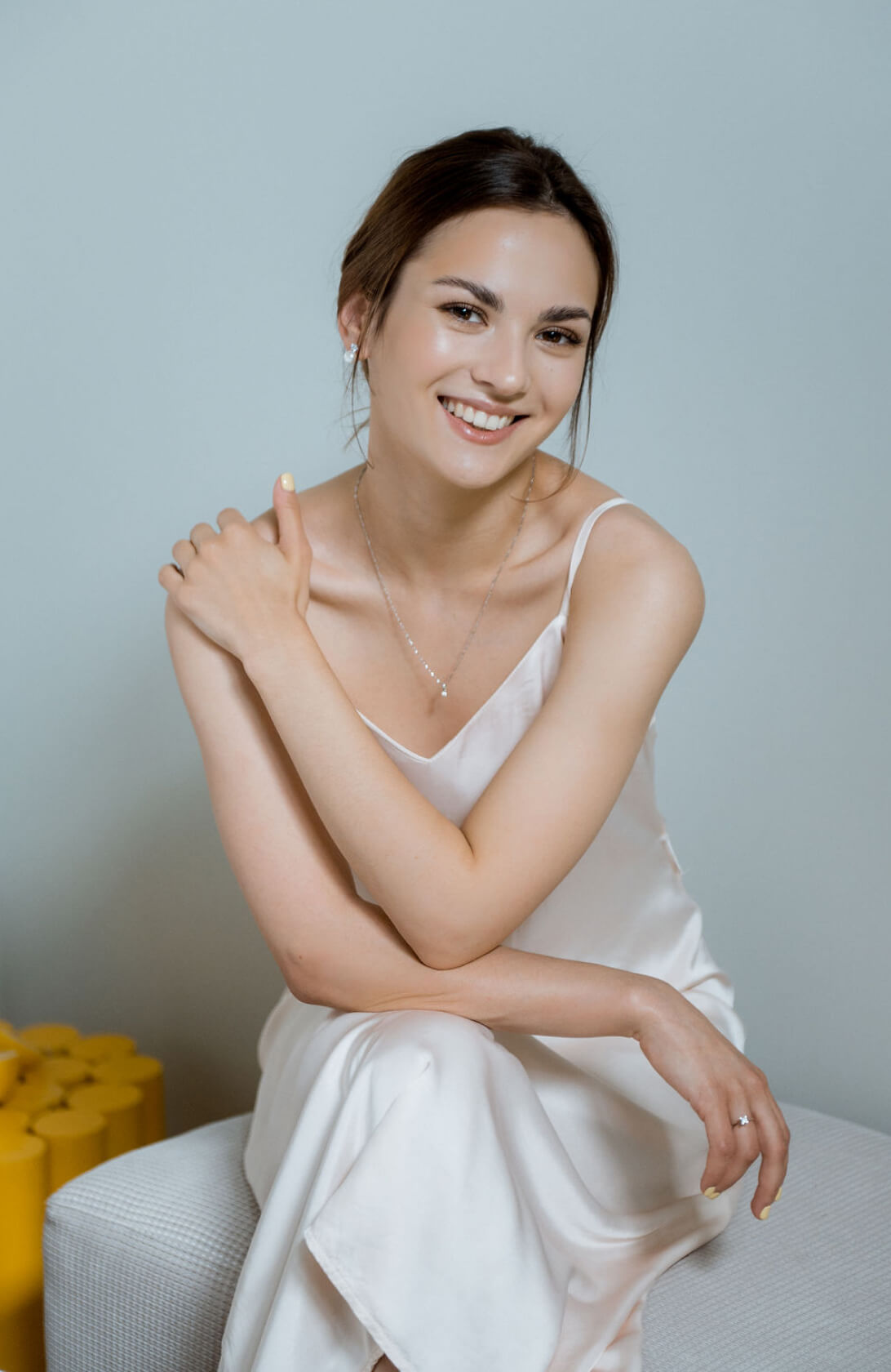 Невеста с нюдовым макияжем сидит и улыбается