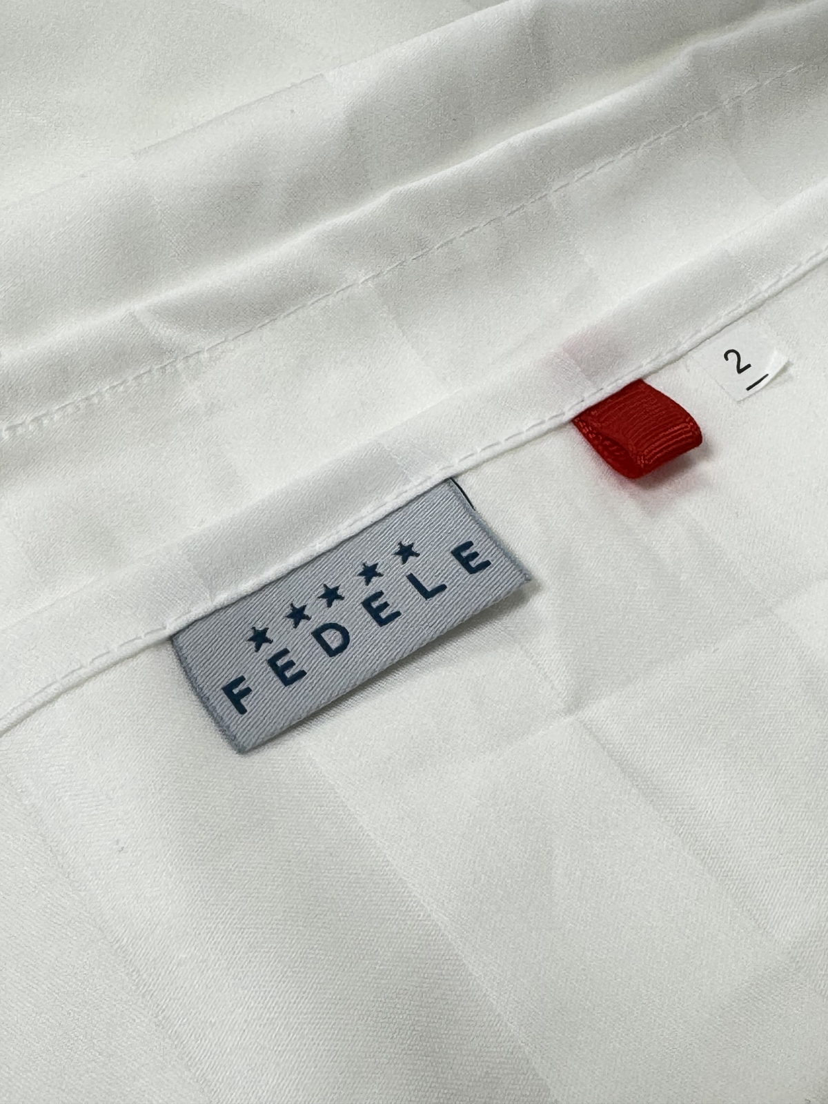 Ярлык FEDELE FOR HOTELS в руке сотрудника производства