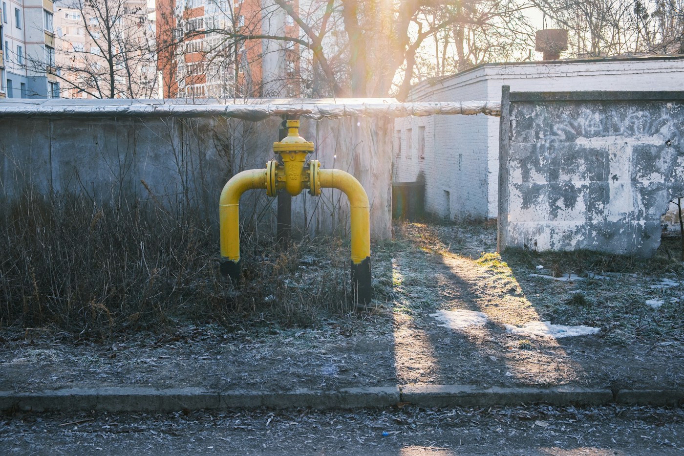 Жёлтый газопровод с задвижкой у жилого дома