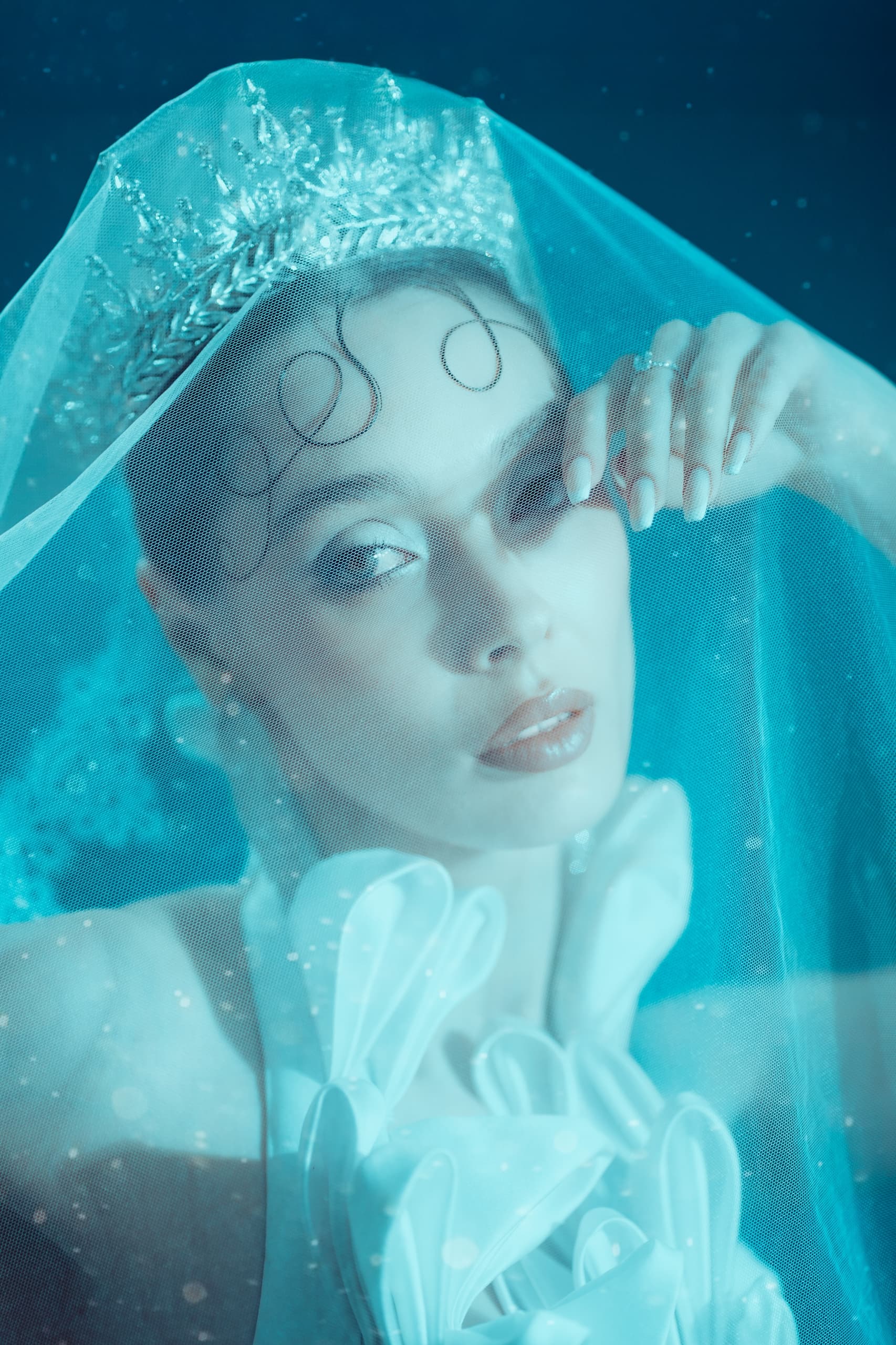 Model in an icy blue veil and sculptural white styling from the Snow Queen editorial