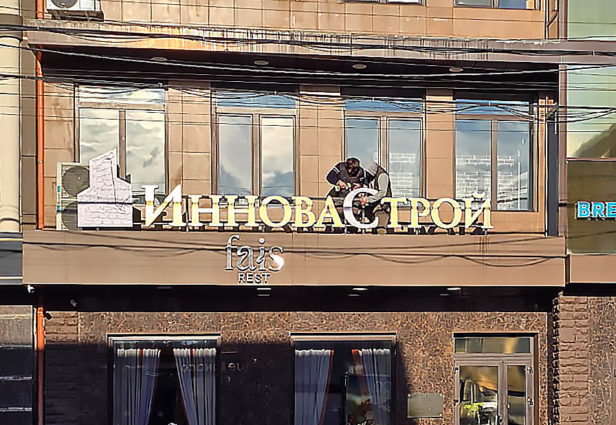 Объемные буквы из черного глянцевого акрила с алюминиевыми бортами и контражурной подсветкой на фоне серебристого композита. В светлое время - стильно и серьёзно. В темное время суток - яркий контур вокруг букв!