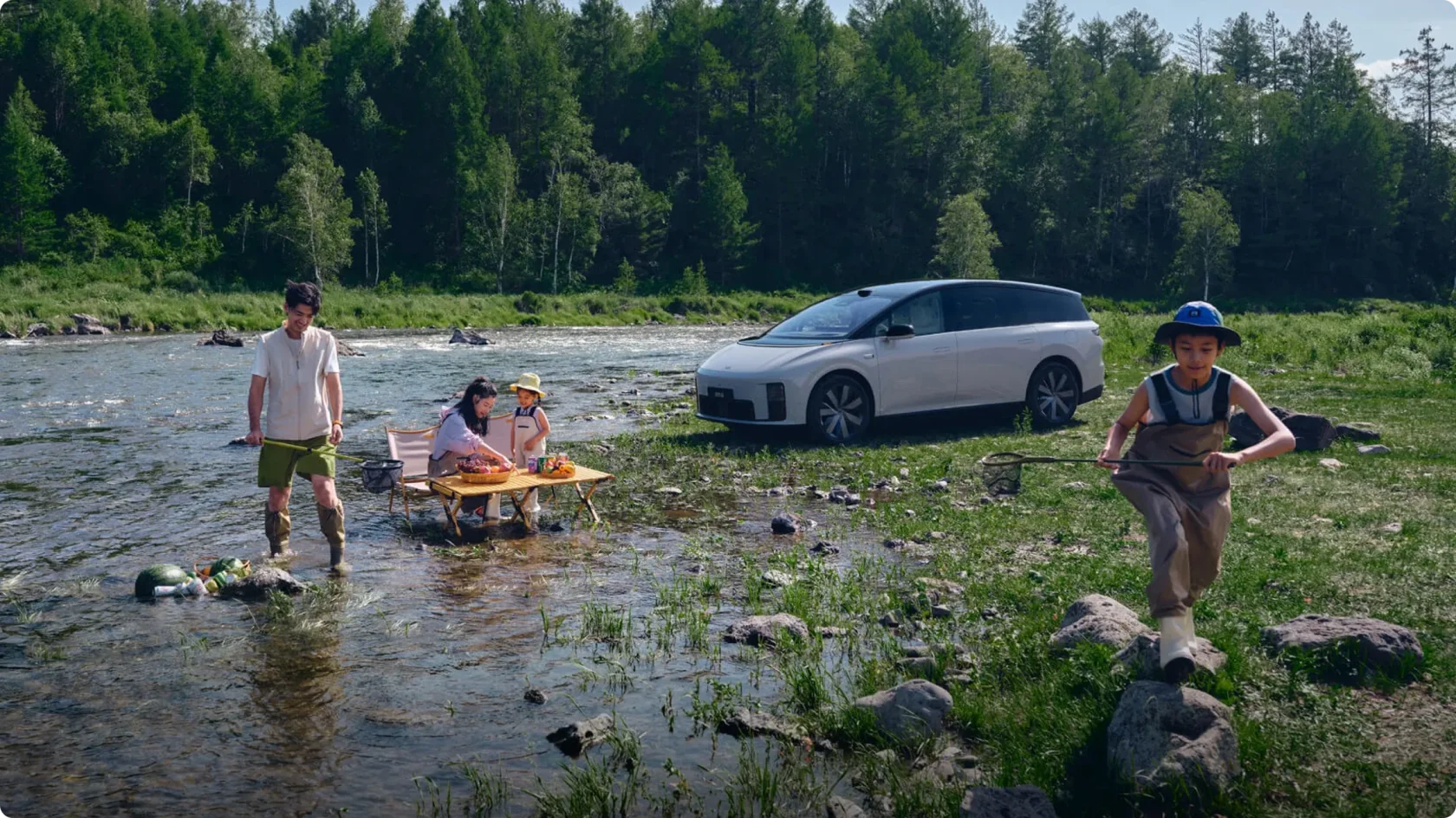 Семейный отдых на природе с Li Auto i8: автомобиль с пневмоподвеской Magic Carpet припаркован у лесной реки, семья рыбачит и устраивает пикник на берегу.
