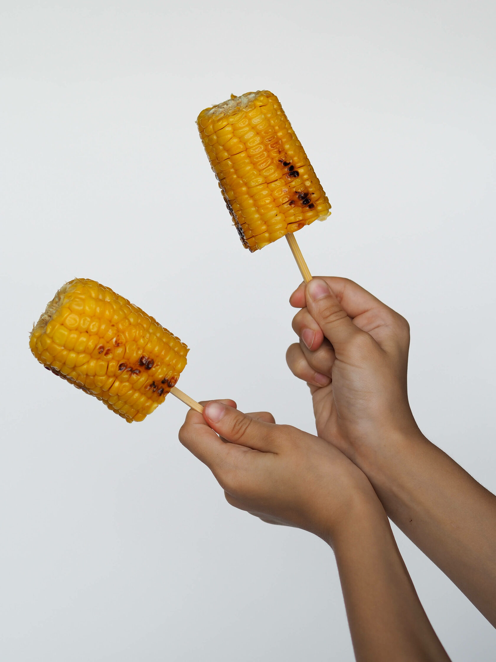 Сладость кукурузу. Вареная кукуруза на палочке. Сладкая кукуруза палочки. Кукуруза сладость. Горячая кукуруза на палочке.