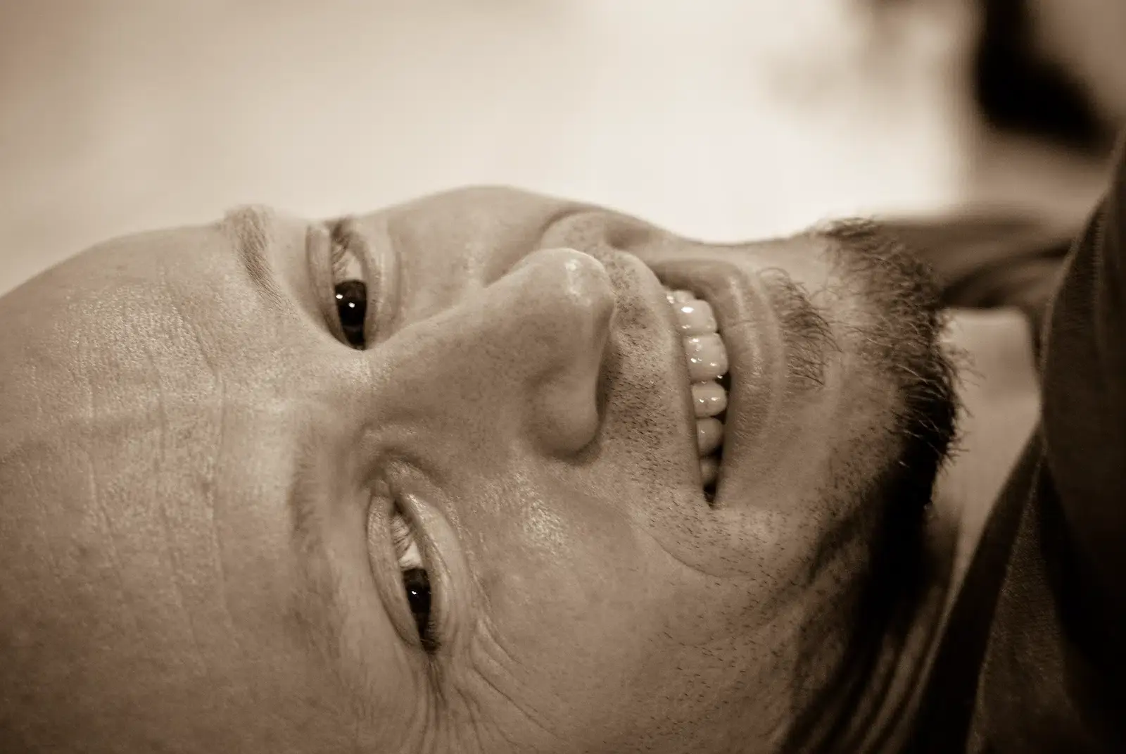 Close-up portrait of a man lying down, face filling the frame with a quiet expression
