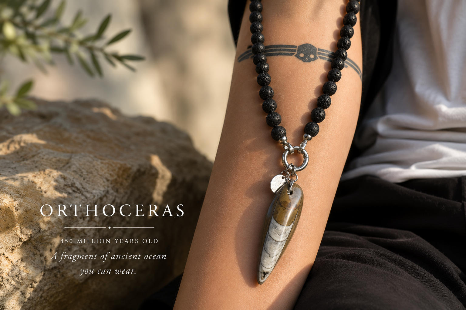 Orthoceras fossil jewellery featuring a 450-million-year-old marine fossil and black lava stone beads handcrafted from authentic Sahara fossils sourced in Morocco.