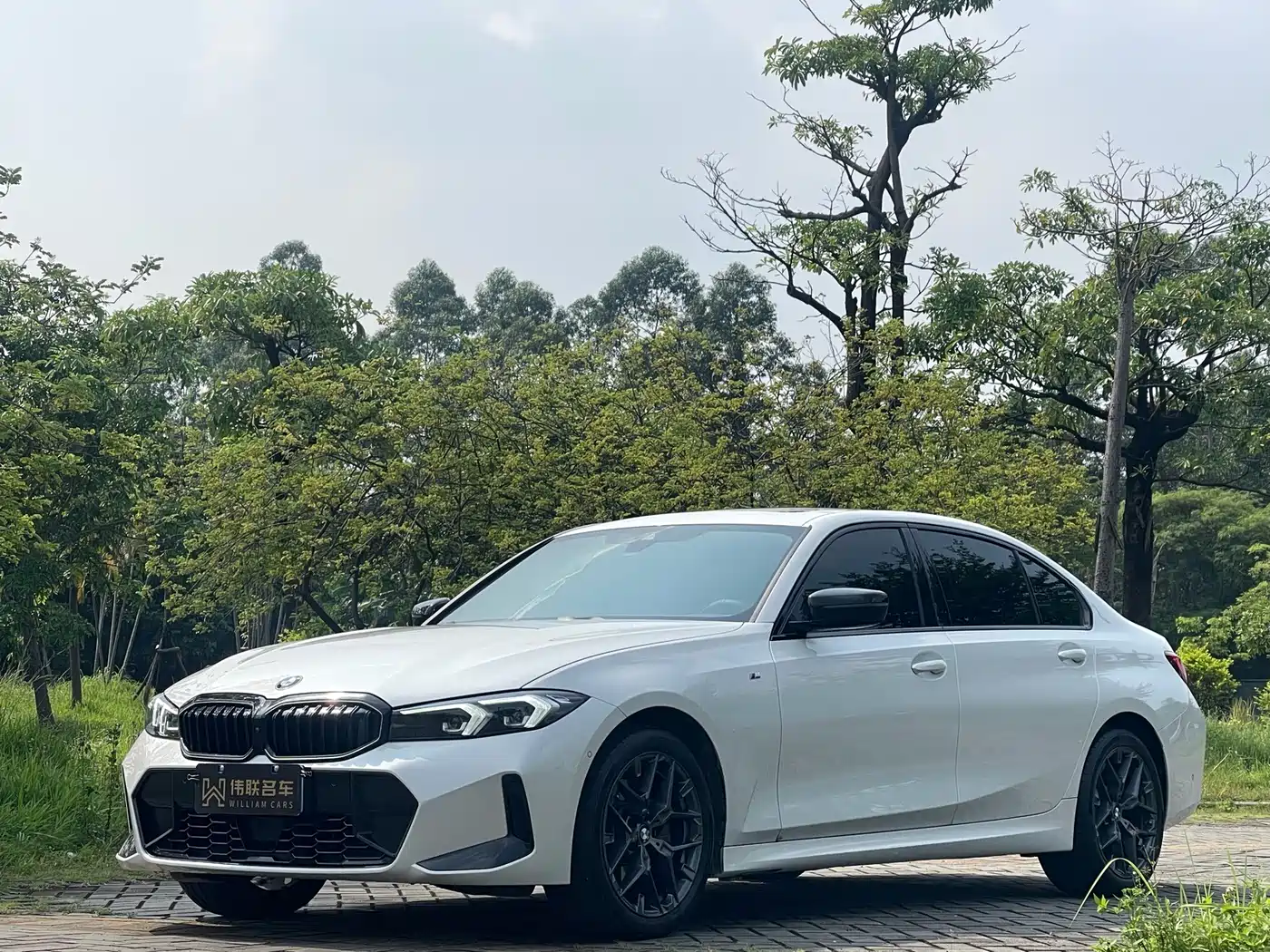 BMW 330Li G28 2025 M Sport Night Package — передняя часть белого седана, ракурс в три четверти