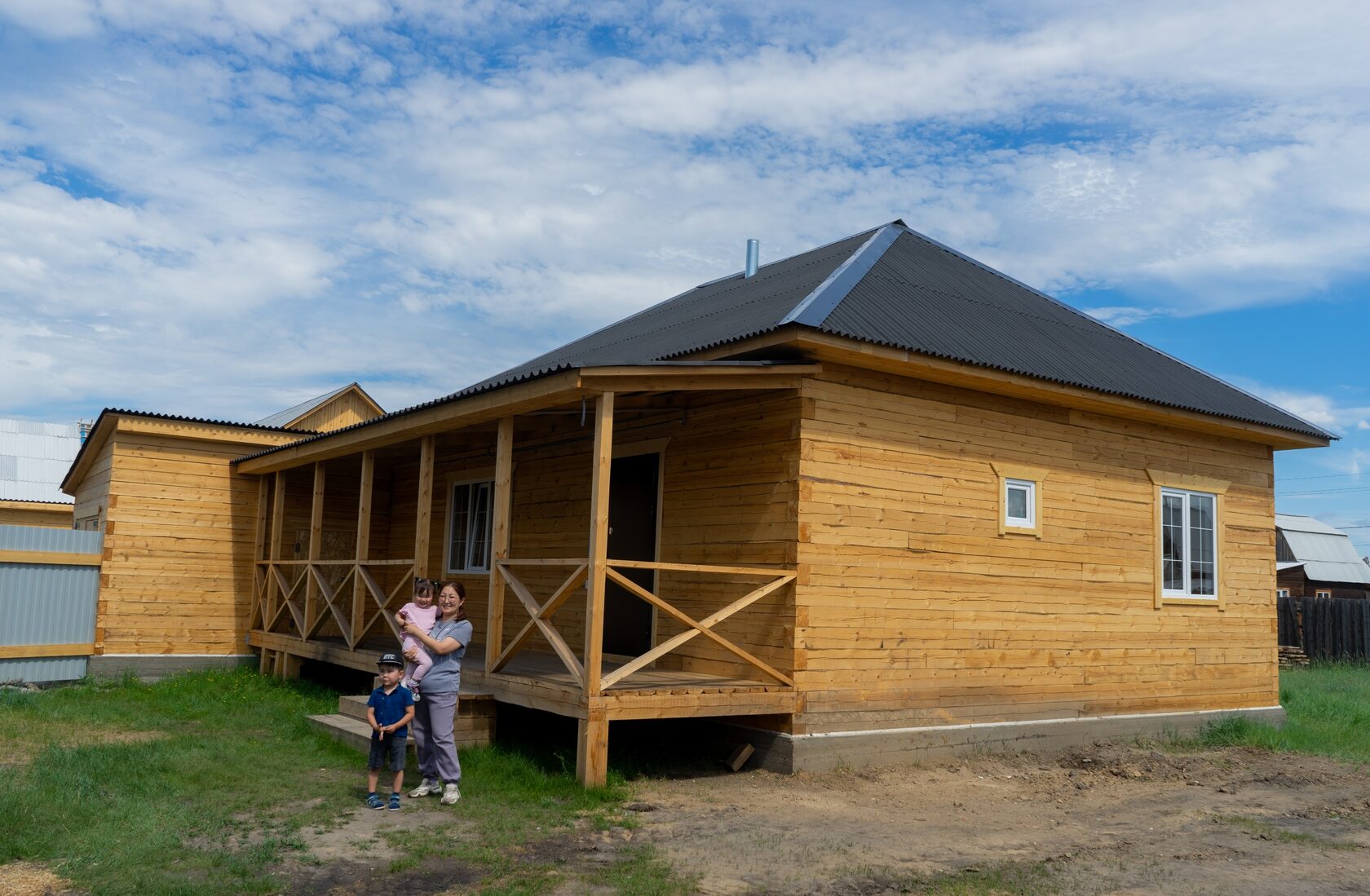 Семья с детьми напротив построенного недавно дома в Улан Удэ