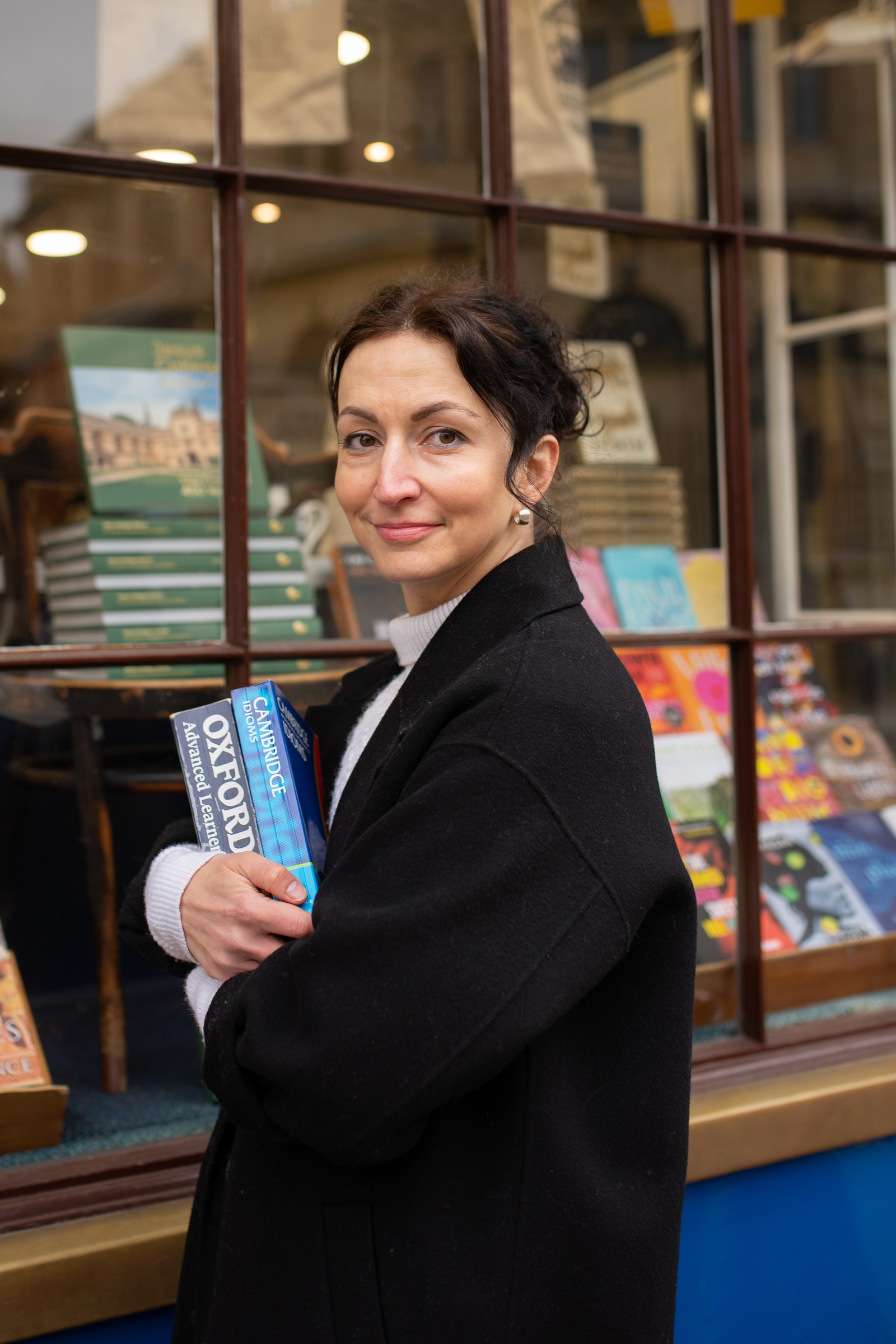 Яна Драпкина у витрины книжного магазина со словарями Oxford и Cambridge