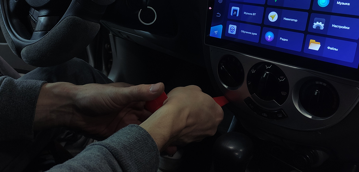Мастер работает с центральной консолью автомобиля