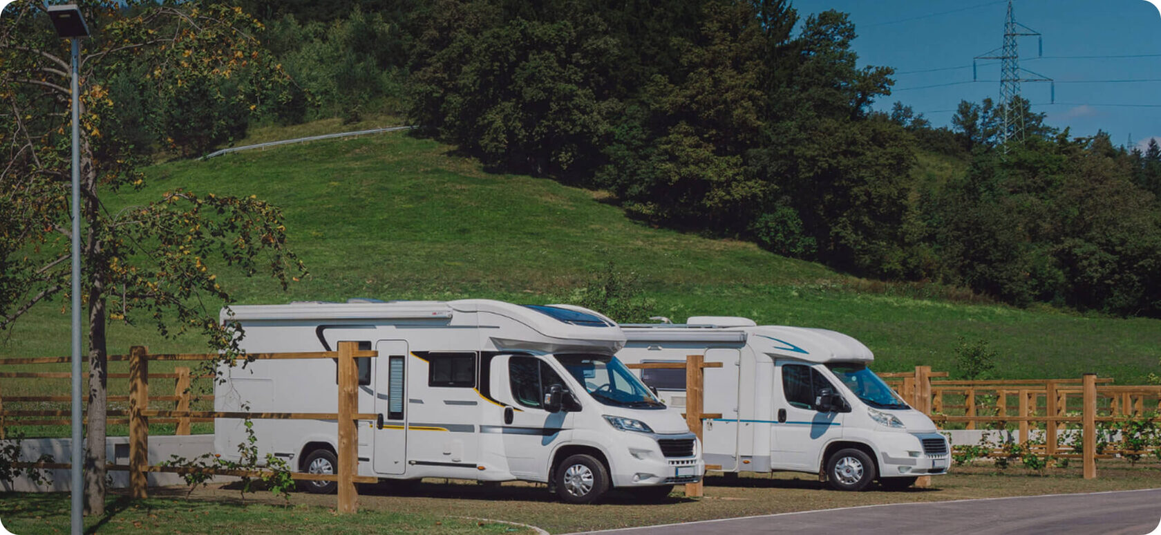 Un guía amigable entregando las llaves de una autocaravana moderna a una pareja joven y emocionada.