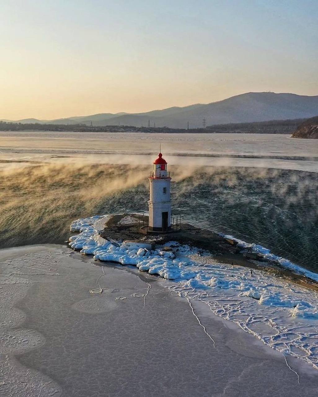 Фото маяка с вертолета в лучах солнца 