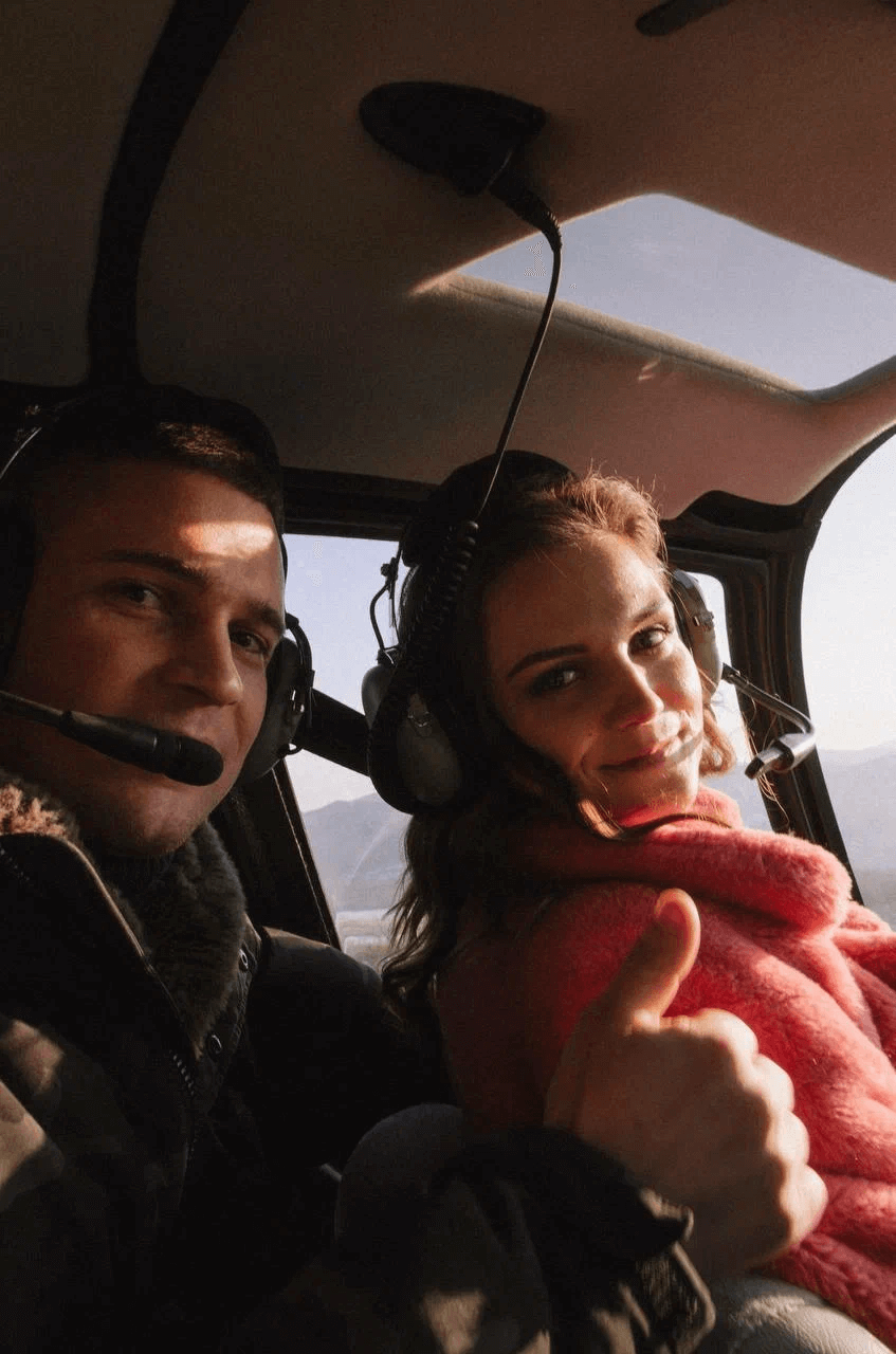 Пассажиры наслаждаются панорамами города из кабины во время прогулки на вертолете по Владивостоку