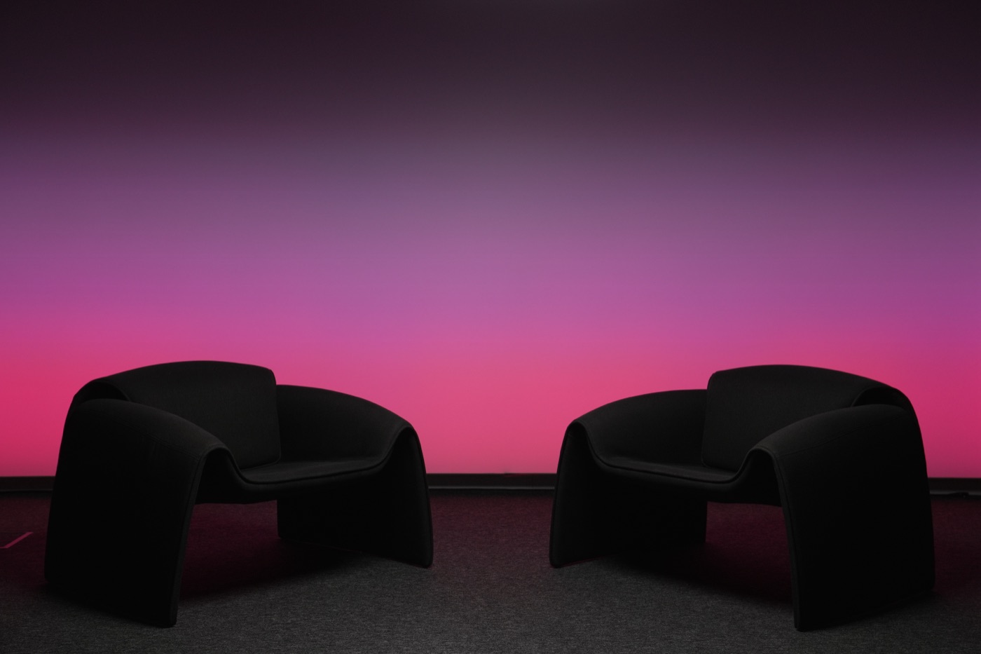 Studio wall lit in a pink and magenta gradient