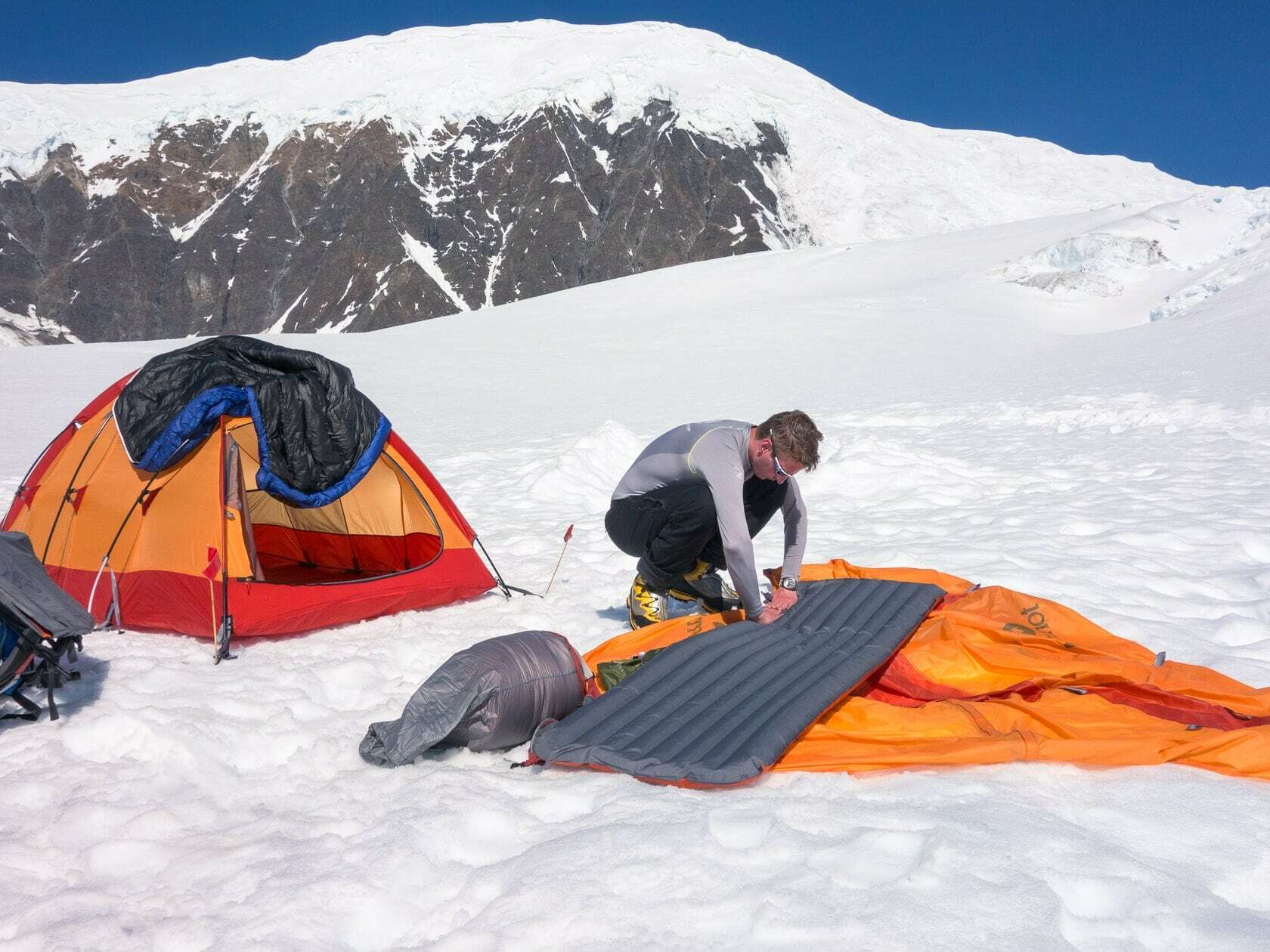 Альпинист устанавливает палатку в горах Аляски