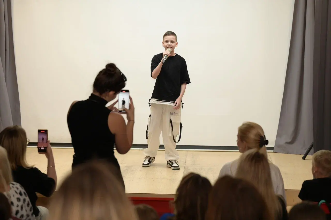 Мальчик выступает на сцене и поет