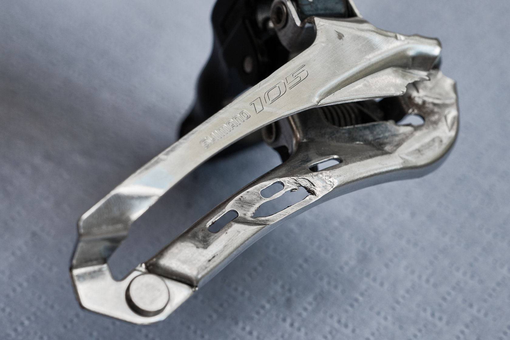 Протёртая цепью до дыры рамка переднего переключателя Shimano 105 в мастерской