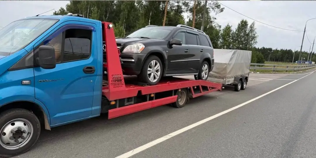 Эвакуатор с фаркопом буксирует прицеп